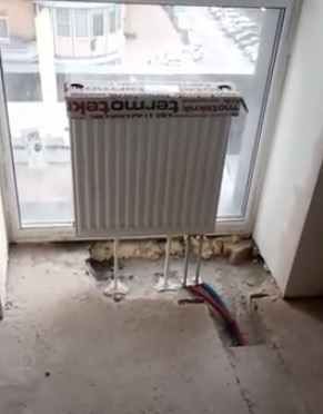 стальной радиатор на стойке у стекла